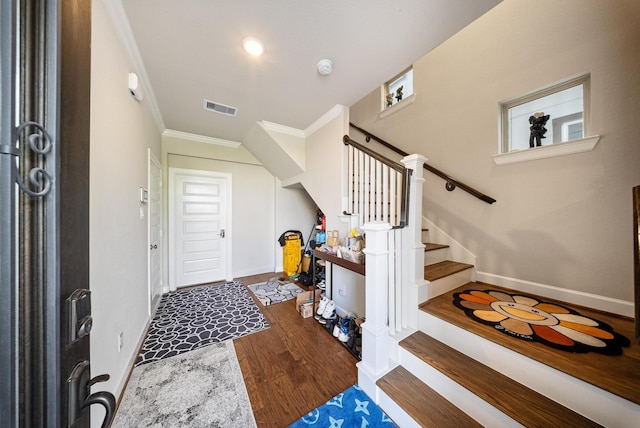 foyer featuring dark wood-type flooring and ornamental molding