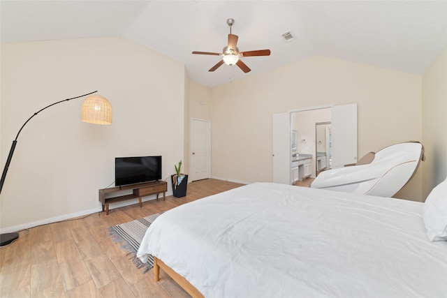 bedroom with ceiling fan, lofted ceiling, connected bathroom, and wood-type flooring