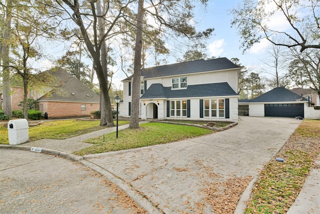 view of front of home featuring a garage, an outdoor structure, and a front lawn