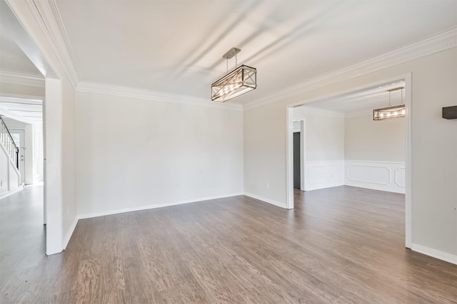 empty room with ornamental molding, dark wood-type flooring, and a chandelier