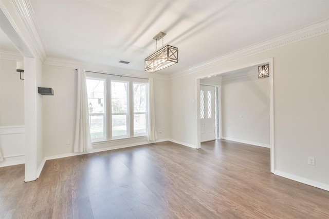 empty room with crown molding and hardwood / wood-style floors