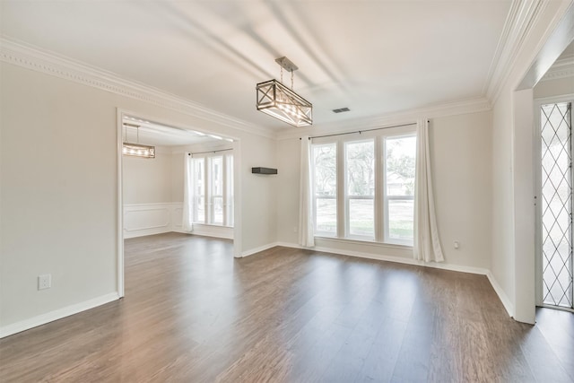 empty room with crown molding, dark hardwood / wood-style floors, and a chandelier