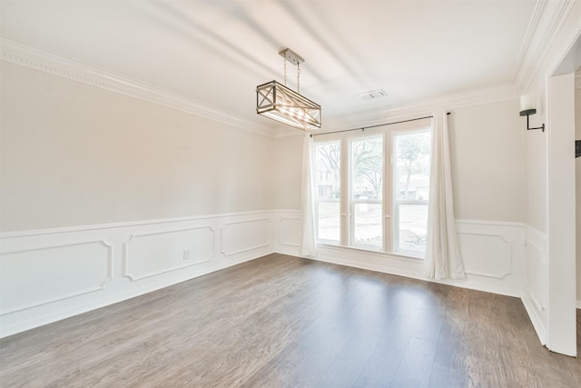 spare room featuring hardwood / wood-style flooring and crown molding