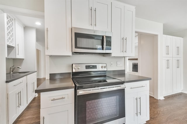 kitchen with white cabinetry, stainless steel appliances, and dark hardwood / wood-style floors