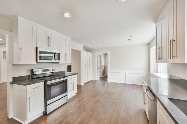 kitchen with white cabinetry, sink, light wood-type flooring, and appliances with stainless steel finishes