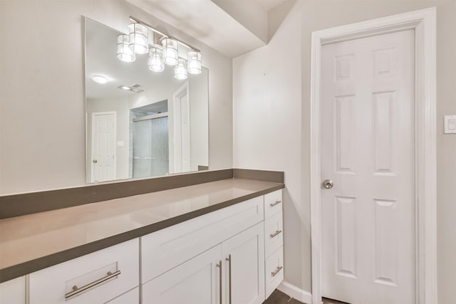 bathroom with vanity and a shower with door