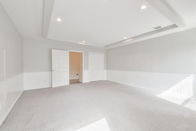 carpeted empty room featuring a tray ceiling