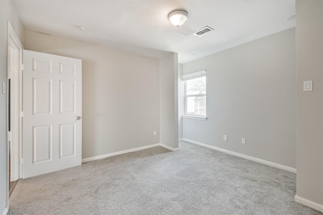 unfurnished room featuring light carpet