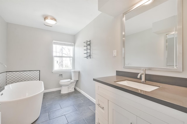 bathroom featuring toilet, vanity, and a bath