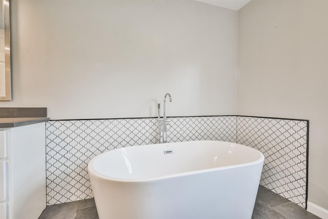 bathroom featuring tile walls, tile patterned flooring, a bathtub, and vanity