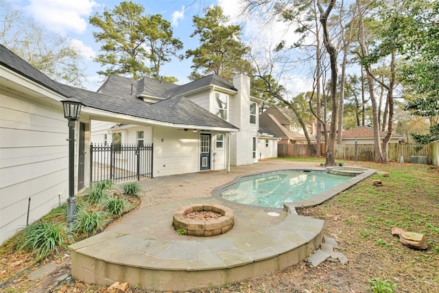 view of pool with an in ground hot tub and an outdoor fire pit