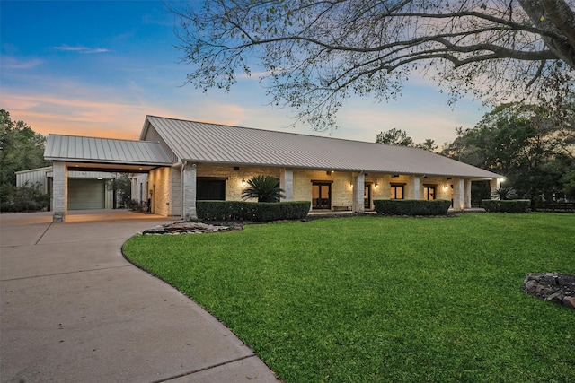 view of front of property with a garage, a yard, and a carport