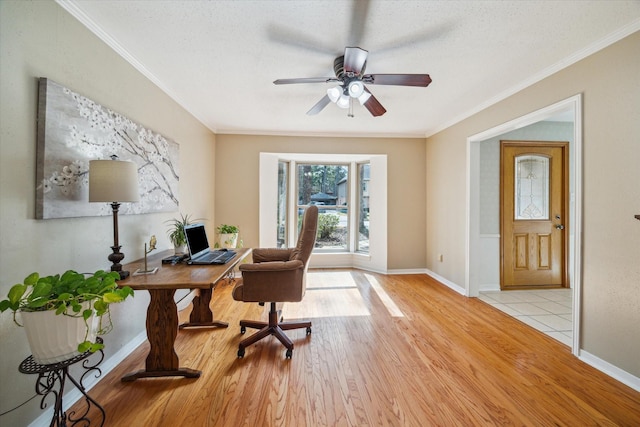 office area with light wood-style flooring, ornamental molding, and baseboards