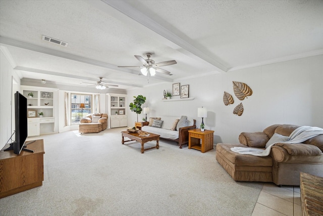 living area with visible vents, ornamental molding, a textured ceiling, and beamed ceiling