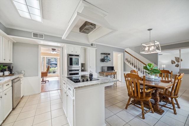 kitchen with light tile patterned floors, stainless steel appliances, visible vents, and a center island