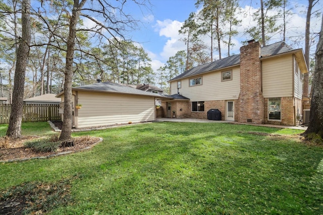 rear view of house featuring a patio, brick siding, fence, a lawn, and a chimney