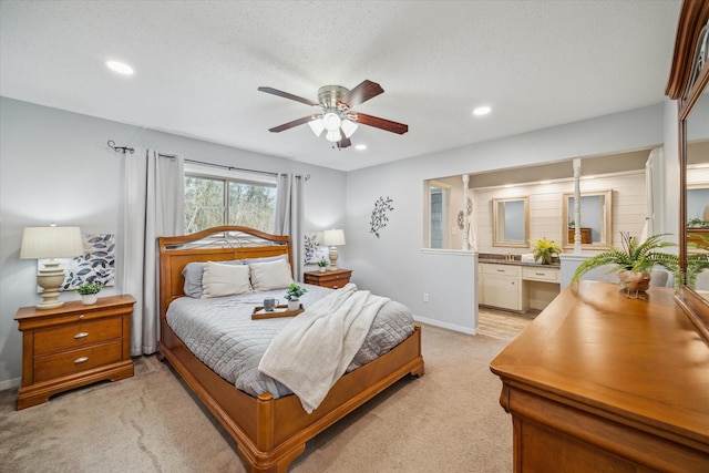 bedroom with baseboards, a ceiling fan, light colored carpet, ensuite bath, and recessed lighting