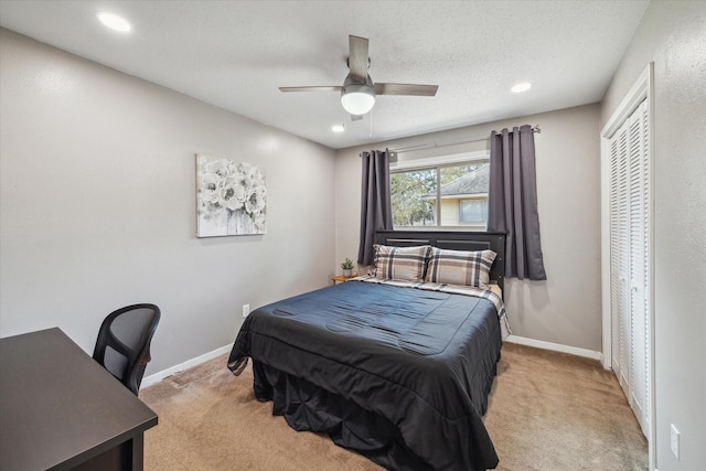 bedroom with light carpet, a textured ceiling, and baseboards