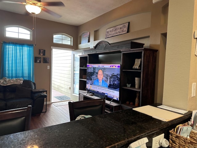 living room with hardwood / wood-style flooring, ceiling fan, lofted ceiling, and a textured ceiling