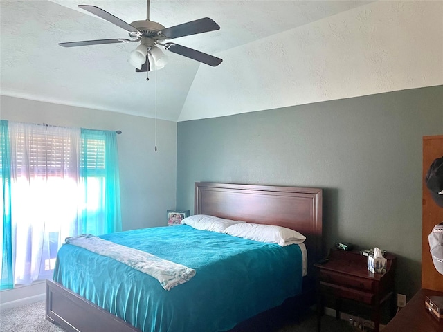 bedroom featuring lofted ceiling, a textured ceiling, carpet floors, and ceiling fan