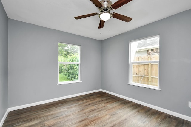 spare room featuring dark wood-type flooring and ceiling fan