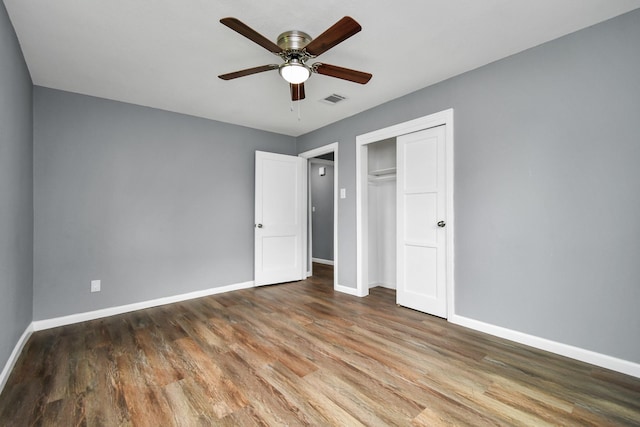 unfurnished bedroom with wood-type flooring, a closet, and ceiling fan