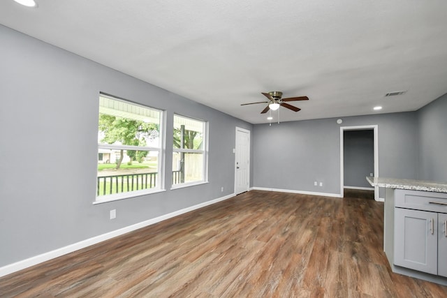 unfurnished living room featuring ceiling fan and dark hardwood / wood-style floors