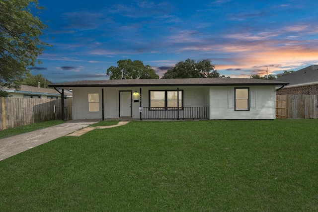 ranch-style house with a lawn, a carport, and a porch