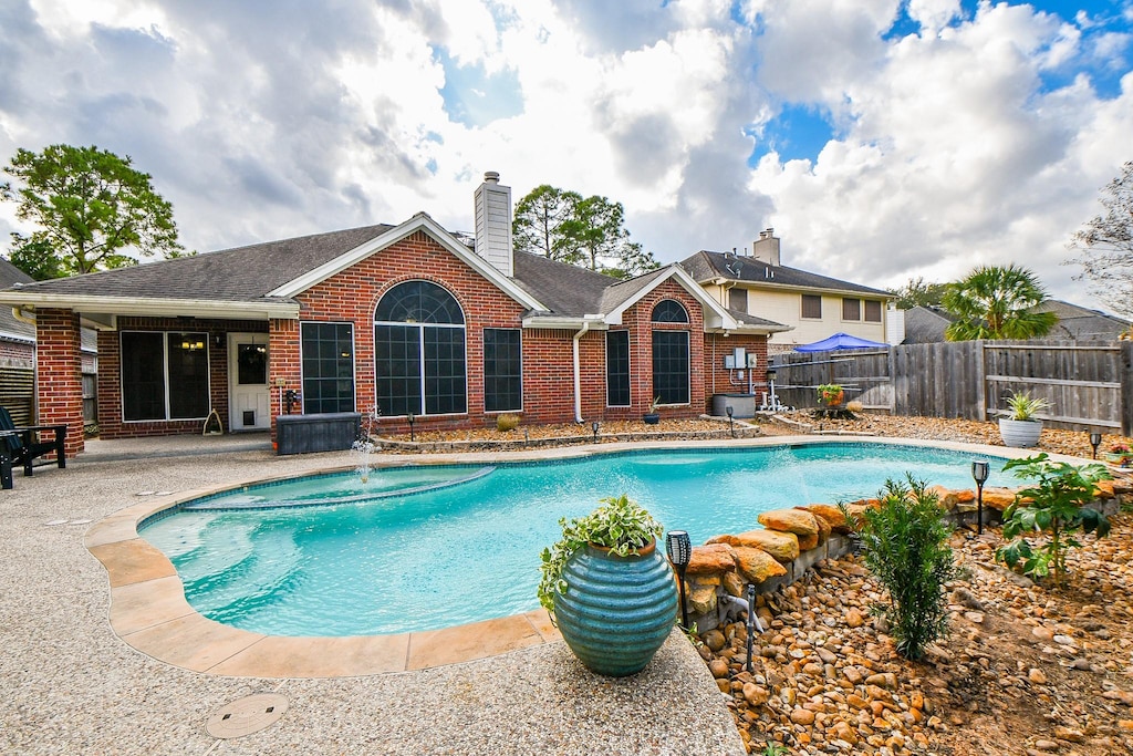 view of pool featuring pool water feature and a patio