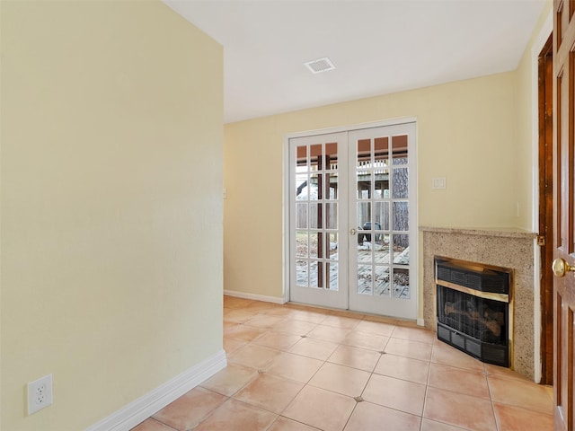 interior space with heating unit, light tile patterned floors, and french doors