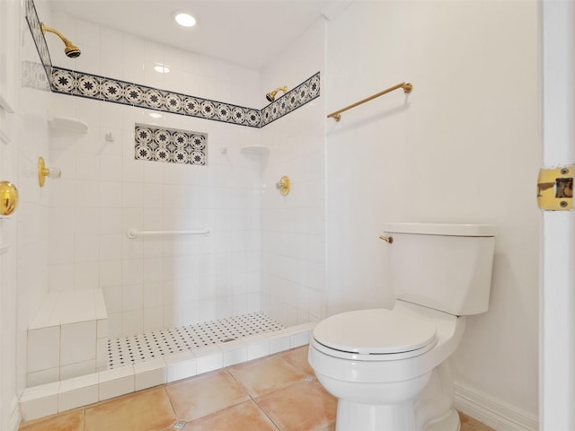 bathroom featuring tile patterned floors, toilet, and tiled shower