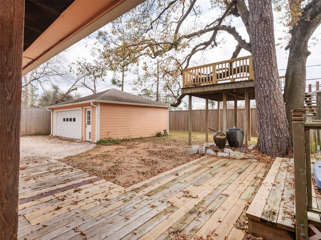 wooden terrace featuring a garage and an outbuilding