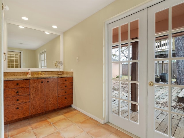 bathroom with tile patterned flooring, vanity, and french doors