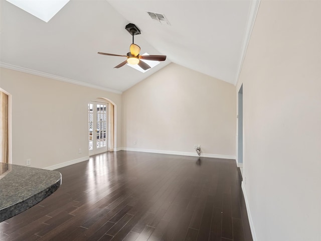 unfurnished living room featuring vaulted ceiling with skylight, dark hardwood / wood-style flooring, ceiling fan, crown molding, and french doors