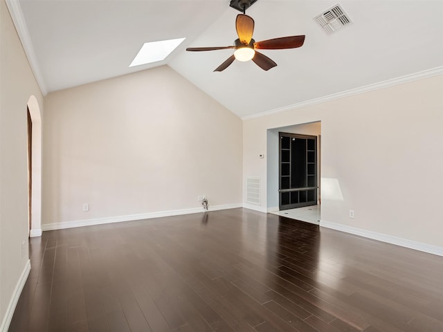 spare room featuring dark wood-type flooring, ceiling fan, ornamental molding, and vaulted ceiling with skylight