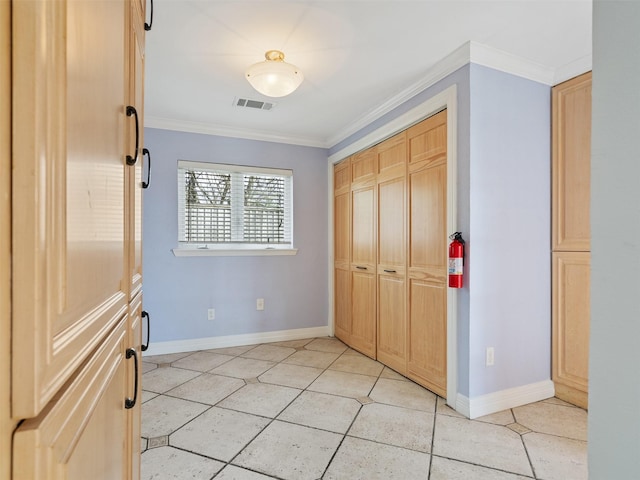 unfurnished bedroom with light tile patterned floors, crown molding, and a closet