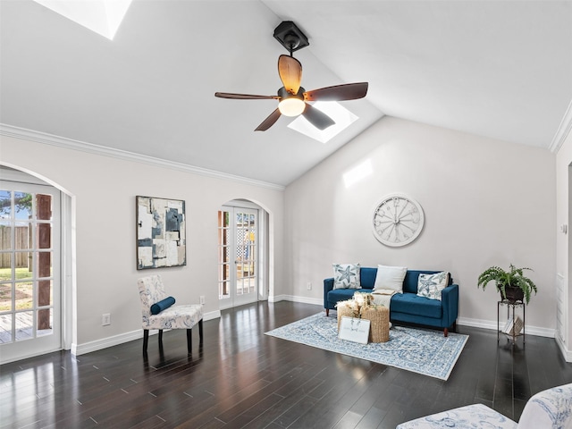 living room featuring arched walkways, ceiling fan, vaulted ceiling with skylight, and plenty of natural light