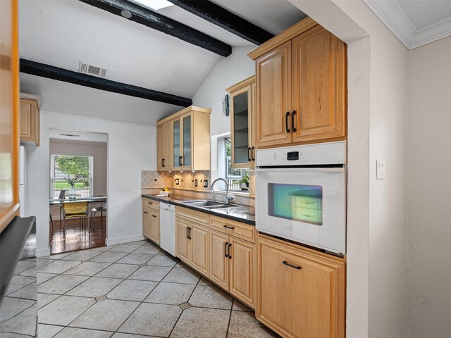 kitchen with decorative backsplash, a sink, visible vents, white appliances, and vaulted ceiling with beams
