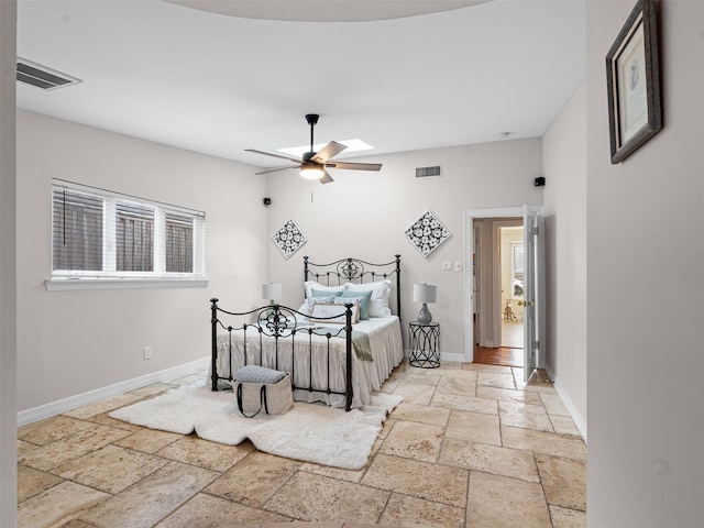bedroom featuring stone tile flooring, ceiling fan, visible vents, and baseboards