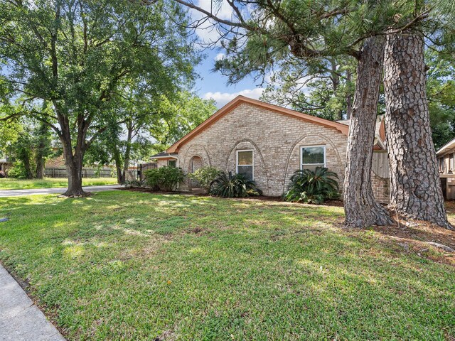 mediterranean / spanish-style home with a front yard and brick siding