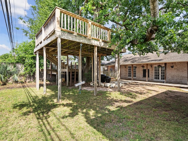 view of yard featuring a deck, french doors, and stairs