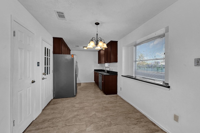 kitchen featuring pendant lighting, sink, a notable chandelier, dark brown cabinetry, and stainless steel appliances