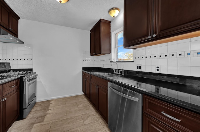 kitchen with sink, tasteful backsplash, a textured ceiling, dark stone countertops, and stainless steel appliances