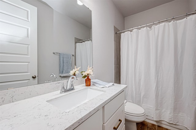 full bathroom with toilet, a shower with curtain, wood finished floors, and vanity