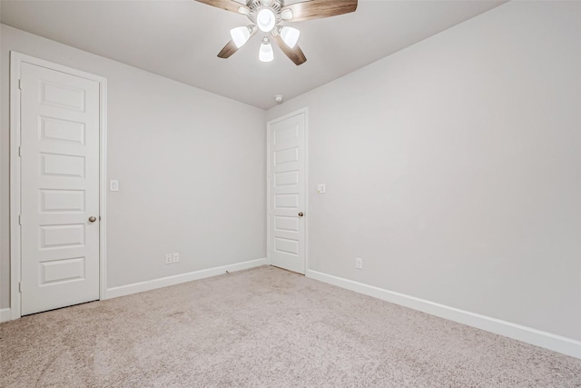 carpeted spare room with ceiling fan and baseboards