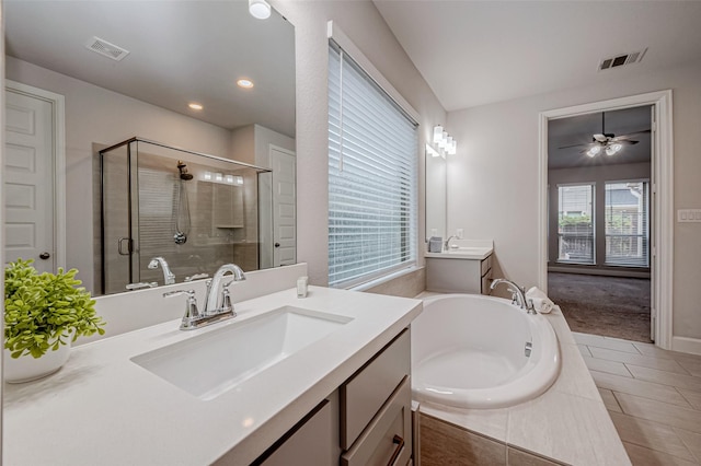 full bath featuring a garden tub, two vanities, a sink, visible vents, and a stall shower