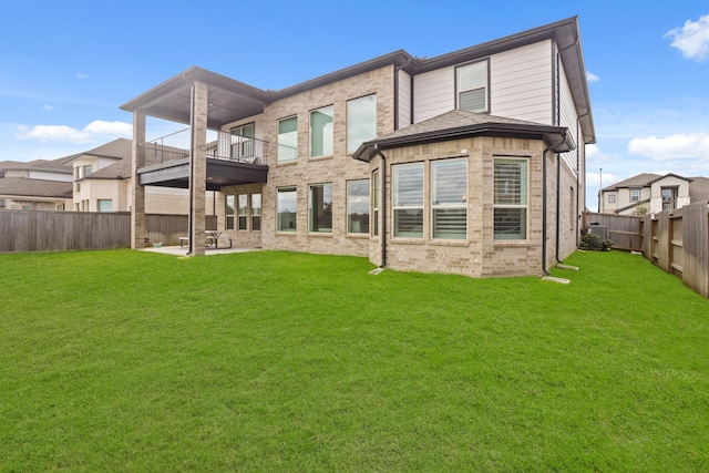 back of property featuring a balcony, a yard, and a patio area