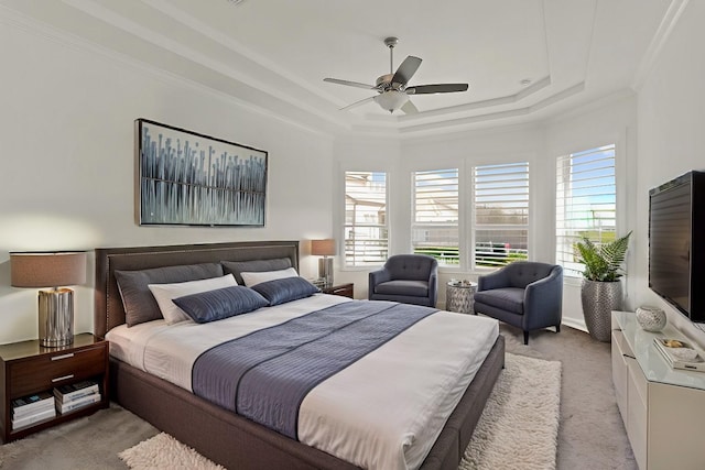 carpeted bedroom with ornamental molding, a raised ceiling, and ceiling fan