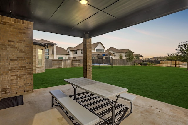 patio terrace at dusk with a yard and a trampoline