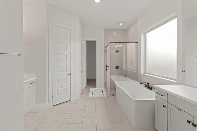 bathroom featuring vanity and shower with separate bathtub